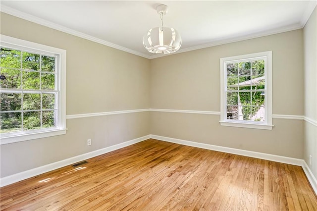 spare room featuring baseboards, an inviting chandelier, visible vents, and plenty of natural light