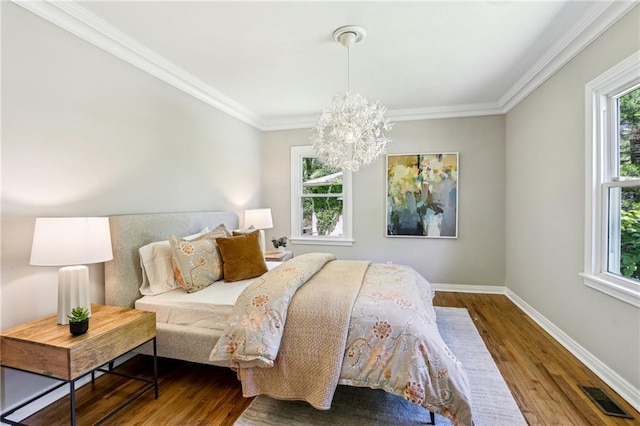 bedroom featuring baseboards, a notable chandelier, wood finished floors, and visible vents