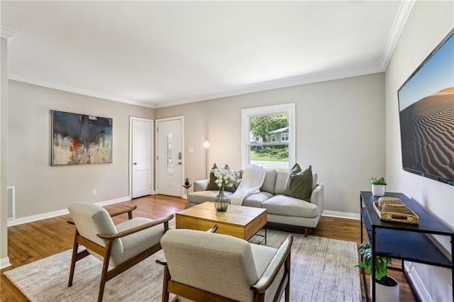 living area featuring wood finished floors, visible vents, crown molding, and baseboards