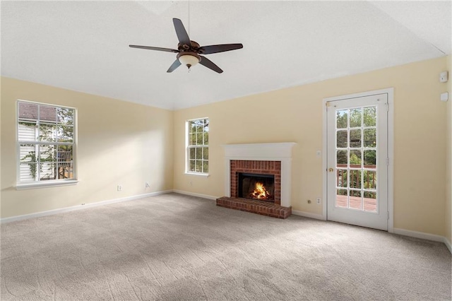 unfurnished living room featuring a healthy amount of sunlight, light colored carpet, a fireplace, and ceiling fan