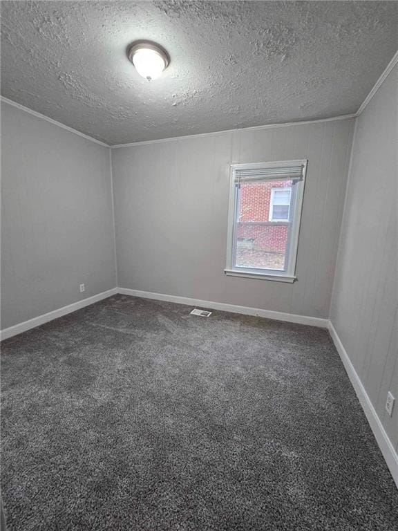 empty room featuring visible vents, crown molding, baseboards, carpet, and a textured ceiling