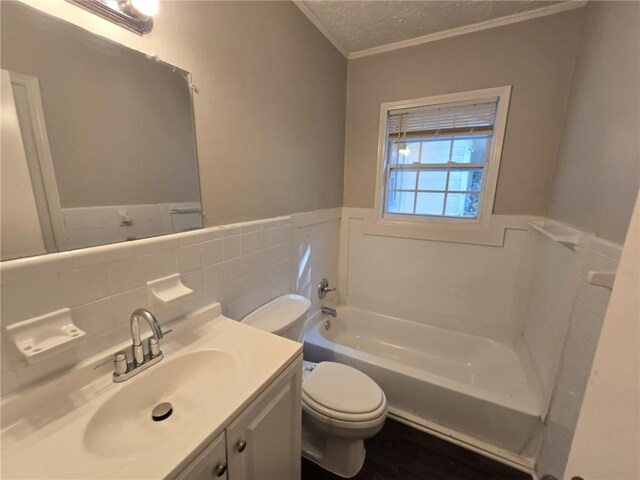 bathroom with a tub to relax in, crown molding, a textured ceiling, toilet, and vanity