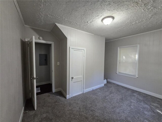 unfurnished bedroom featuring baseboards, electric panel, ornamental molding, a textured ceiling, and carpet flooring