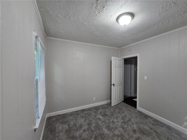 unfurnished bedroom featuring ornamental molding, baseboards, carpet floors, and a textured ceiling