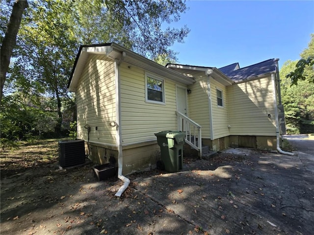 rear view of house with central AC and entry steps