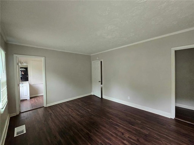 empty room featuring visible vents, a textured ceiling, baseboards, and wood finished floors