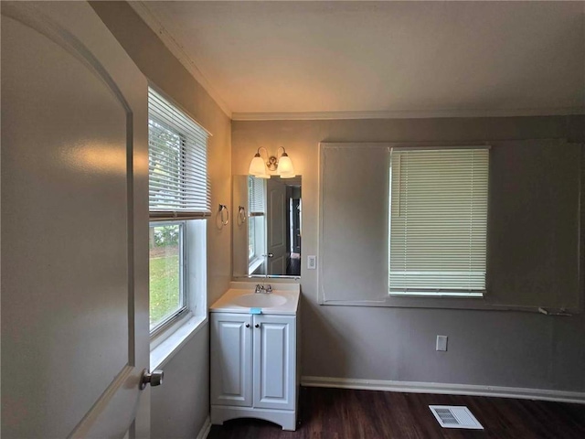 bathroom with visible vents, crown molding, baseboards, wood finished floors, and vanity