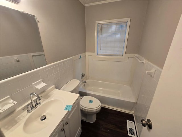 full bath with toilet, a bath, visible vents, and wainscoting