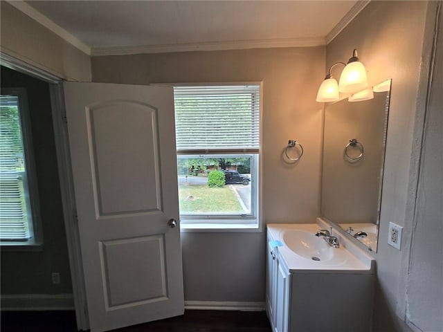 bathroom featuring baseboards, ornamental molding, and vanity