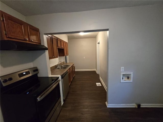 kitchen featuring a sink, baseboards, under cabinet range hood, stainless steel appliances, and dark wood-style flooring