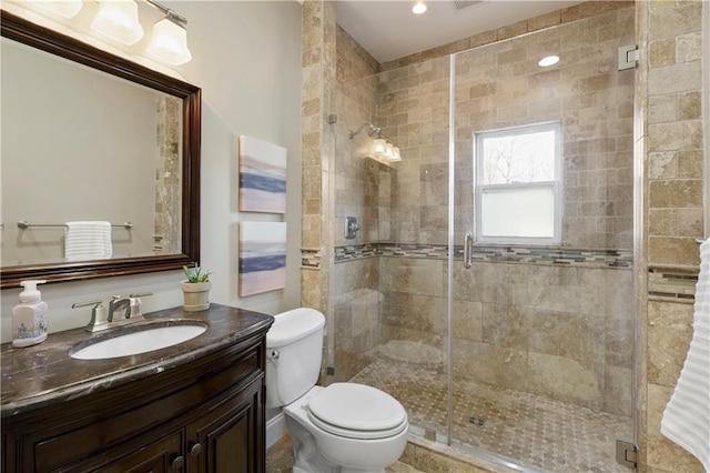 bathroom featuring vanity, toilet, and walk in shower