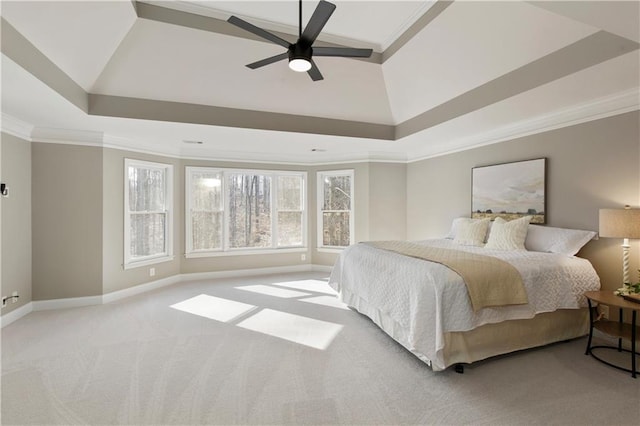 bedroom featuring light colored carpet, ornamental molding, a raised ceiling, and ceiling fan