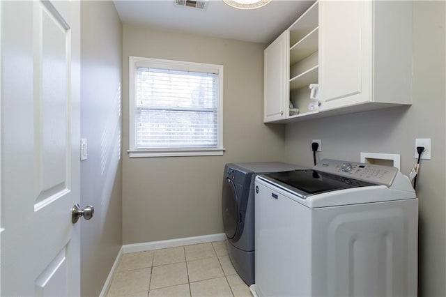 washroom featuring cabinets, washer and dryer, and light tile patterned floors