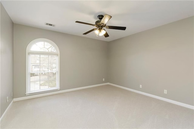 carpeted spare room featuring ceiling fan