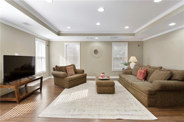 living room featuring crown molding, a tray ceiling, and dark hardwood / wood-style flooring