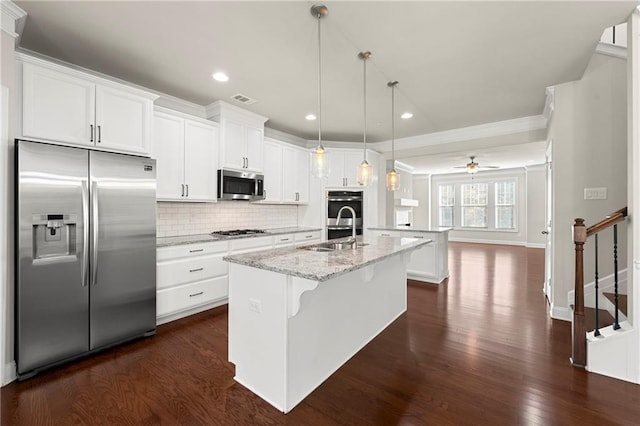 kitchen featuring light stone countertops, ceiling fan, stainless steel appliances, dark hardwood / wood-style flooring, and an island with sink