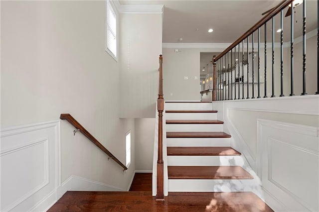 staircase with hardwood / wood-style floors and crown molding