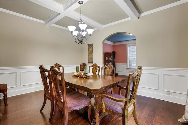 dining room with dark wood-type flooring, beamed ceiling, a chandelier, and crown molding