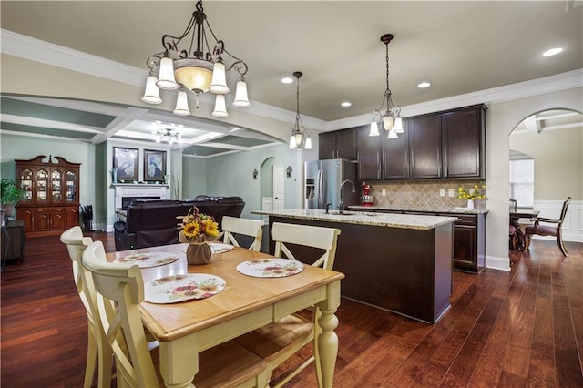 dining space with ornamental molding, dark wood-type flooring, a chandelier, and coffered ceiling