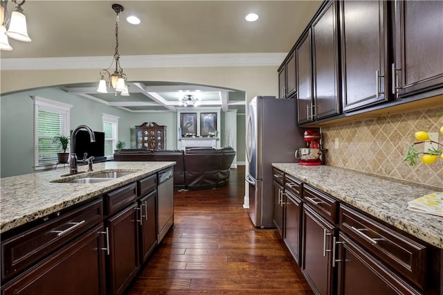 kitchen featuring dark brown cabinetry, dark hardwood / wood-style flooring, hanging light fixtures, sink, and ceiling fan