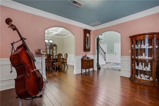 interior space featuring dark wood-type flooring, a chandelier, crown molding, and coffered ceiling