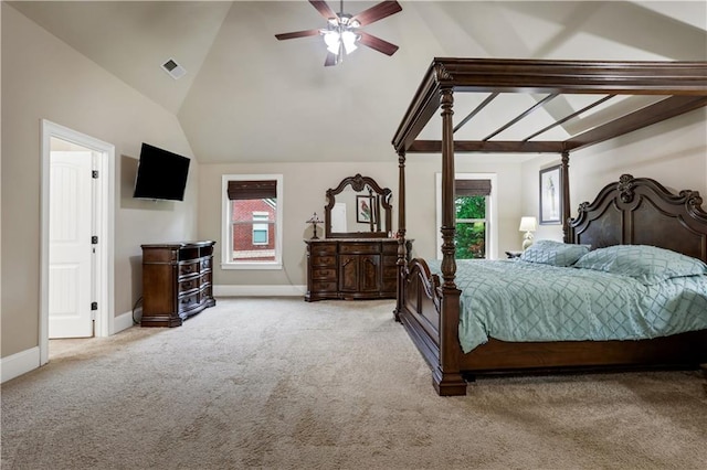 bedroom featuring multiple windows, light colored carpet, ceiling fan, and vaulted ceiling