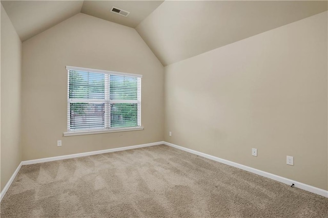 carpeted empty room featuring lofted ceiling