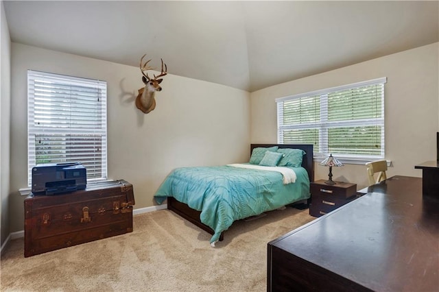 bedroom with light colored carpet, multiple windows, and vaulted ceiling