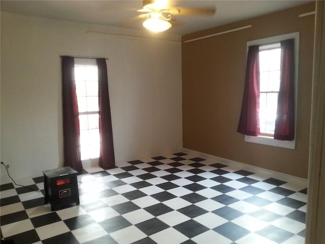 unfurnished room featuring ceiling fan and plenty of natural light