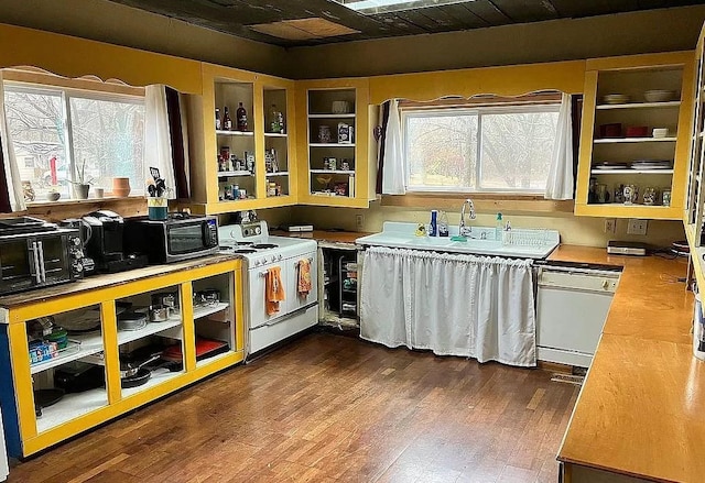 kitchen featuring sink, dark wood-type flooring, white appliances, and a healthy amount of sunlight