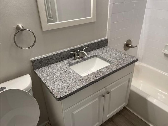 full bathroom with shower / bathing tub combination, hardwood / wood-style flooring, toilet, and large vanity