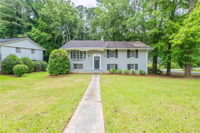 4669 Birch Ridge Trl, Stone Mountain, GA 30083 - split foyer home featuring a front lawn, view of scattered trees, and driveway