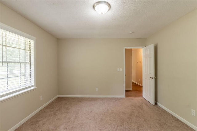 4669 Birch Ridge Trl, Stone Mountain, GA 30083 - empty room featuring plenty of natural light, light carpet, baseboards, and a textured ceiling