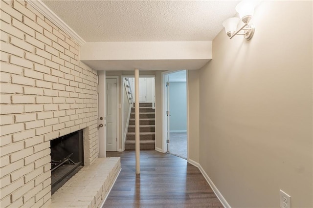 4669 Birch Ridge Trl, Stone Mountain, GA 30083 - unfurnished living room featuring stairs, a textured ceiling, dark wood-style floors, a brick fireplace, and baseboards