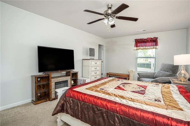 bedroom featuring ceiling fan, light colored carpet, and a fireplace