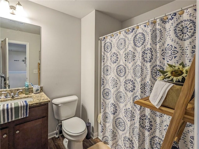 bathroom with toilet, vanity, and hardwood / wood-style flooring