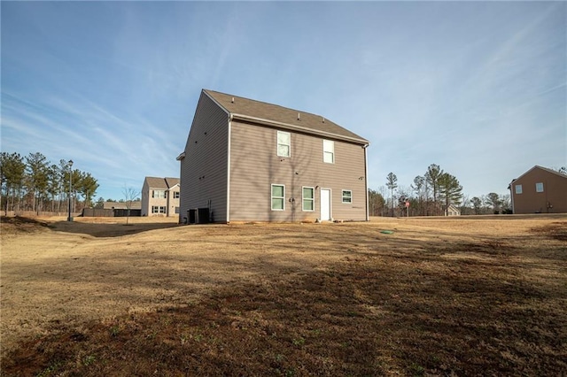 back of house with a yard and central AC unit