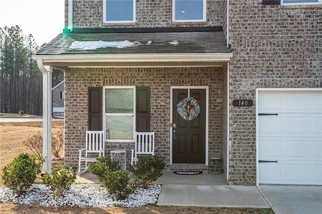 entrance to property with a garage and a porch