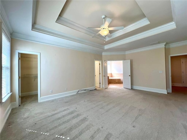 unfurnished bedroom featuring a tray ceiling, carpet, and baseboards