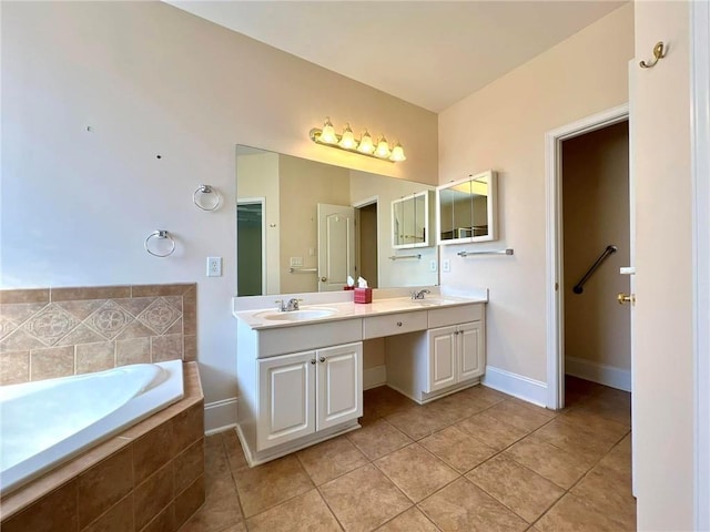 bathroom featuring double vanity, tile patterned flooring, a sink, and a bath