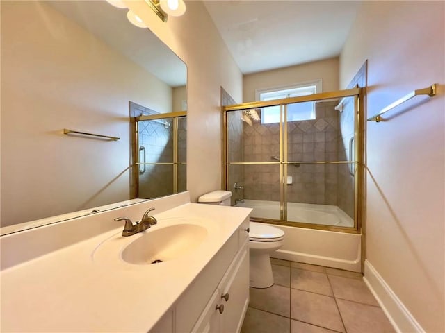 bathroom with baseboards, toilet, tile patterned flooring, combined bath / shower with glass door, and vanity