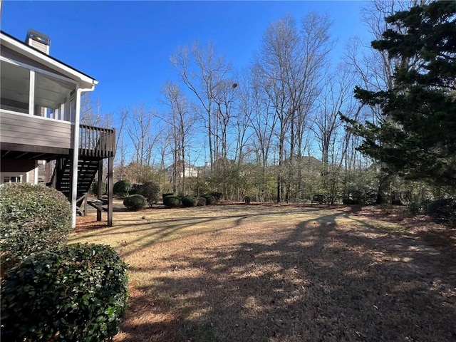 view of yard featuring a sunroom and stairs