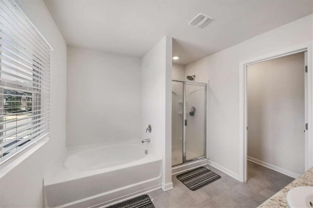 bathroom with a sink, baseboards, visible vents, a stall shower, and a garden tub