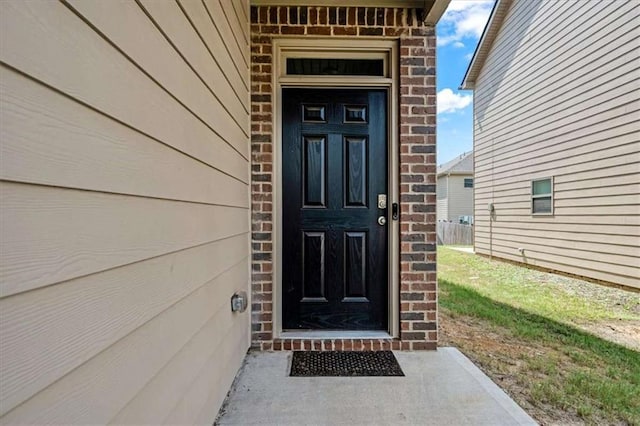 view of exterior entry featuring brick siding