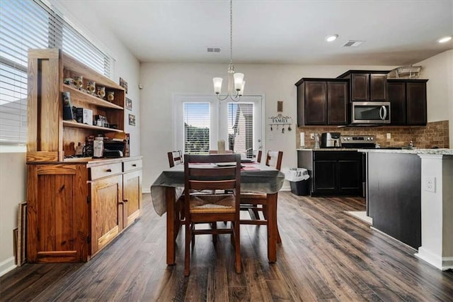 dining space featuring visible vents, a notable chandelier, and dark wood-style flooring