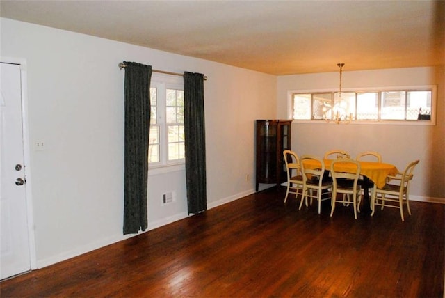 dining room featuring dark wood-type flooring and a chandelier