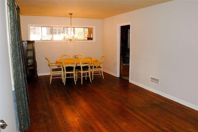 dining room with an inviting chandelier and dark hardwood / wood-style flooring