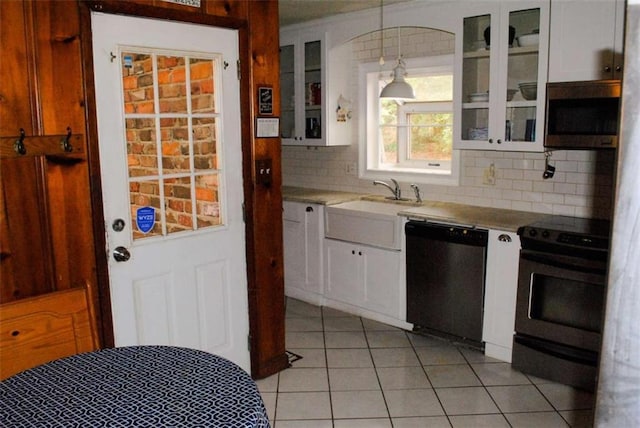 kitchen featuring light tile patterned floors, appliances with stainless steel finishes, tasteful backsplash, decorative light fixtures, and white cabinets