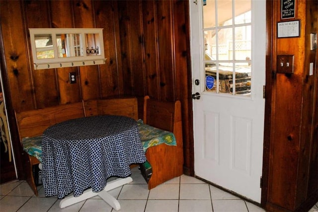 entryway featuring light tile patterned floors and wood walls