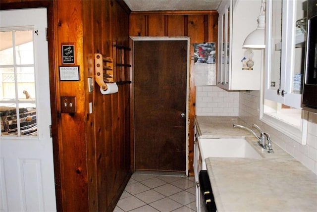 kitchen featuring sink, backsplash, light tile patterned floors, and a healthy amount of sunlight